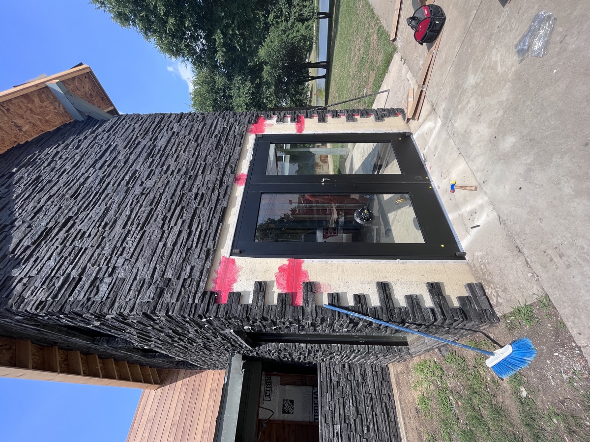 Storefront glass installation on stone facade — commercial new construction