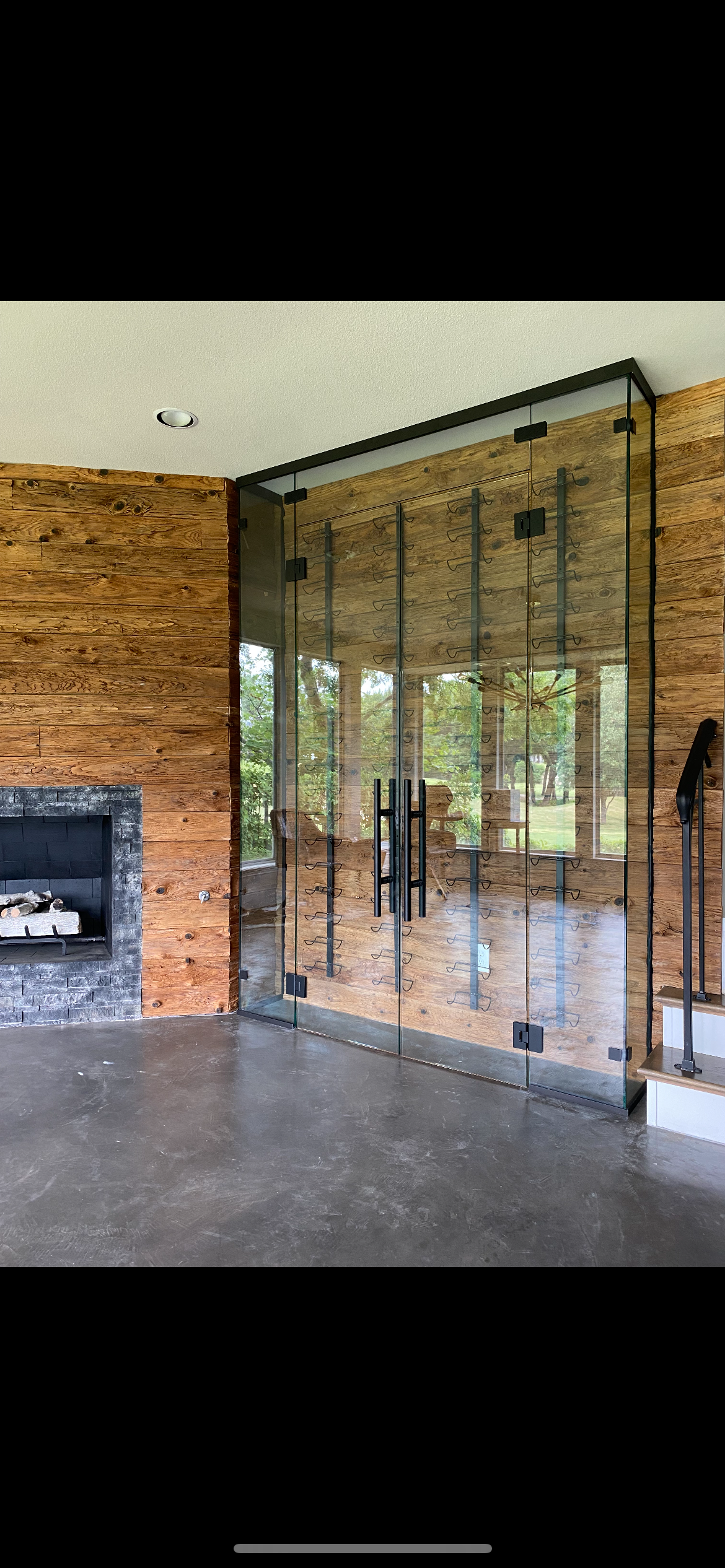 Custom glass wine cellar with rustic wood walls